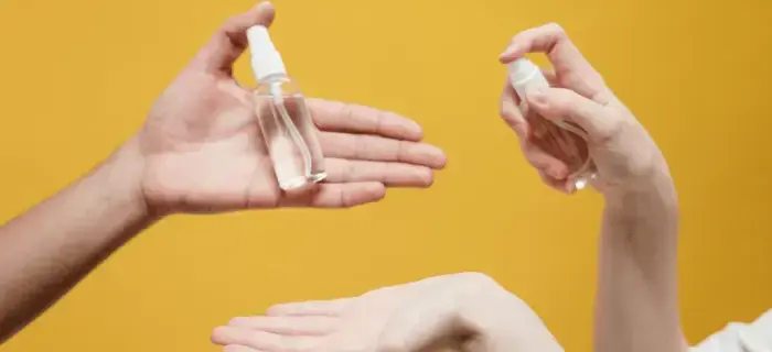 People Holding Clear Glass Bottle